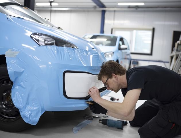 full-shot-man-wrapping-car-indoors